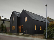 The Black Exterior Of This Home Leads To A Pink Kitchen Inside